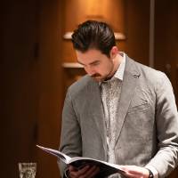 One of the guests reading a program at a cocktail table